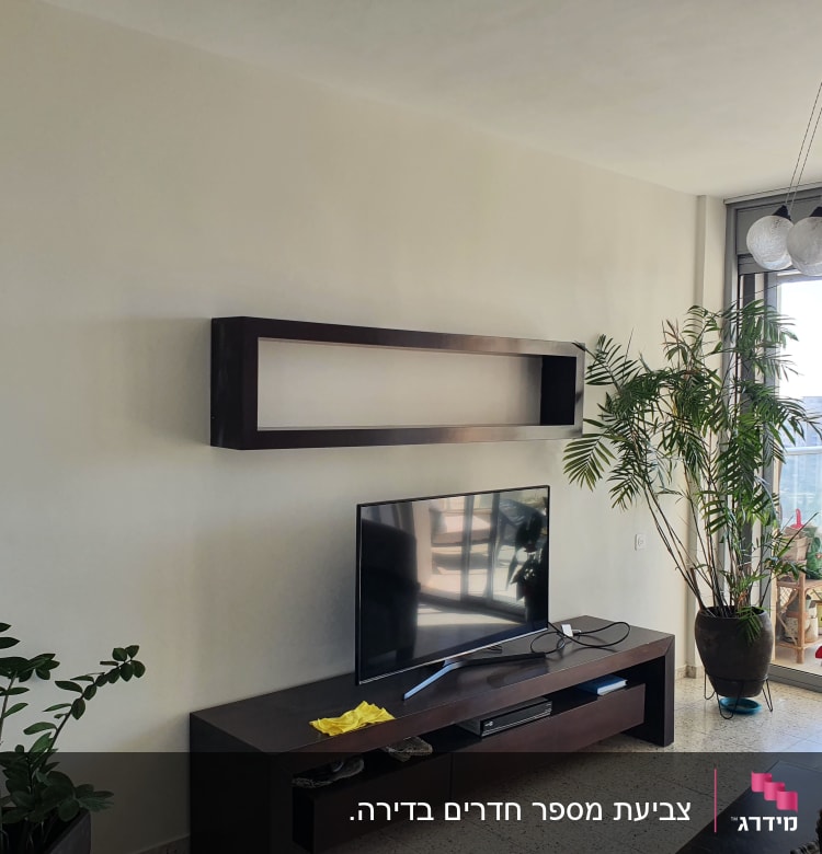 קיר לבן עם מדף עץ כהה בסלון מודרני